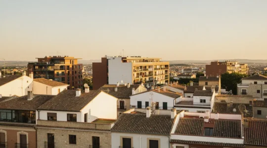 Vista panorámica de edificios residenciales modernos y clásicos en España con cielo dorado al atardecer